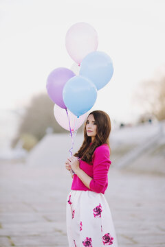 Beautiful young woman holding balloons