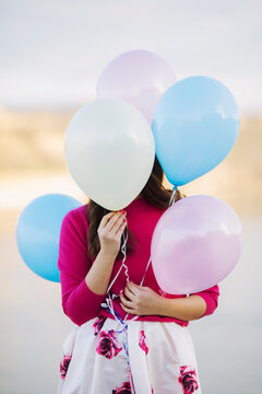 Young woman covering her face with balloons