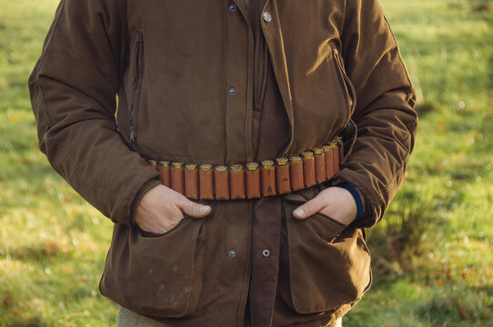 A hunter poses with a belt of shotgun catridges