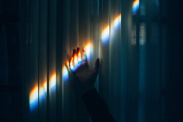 Hand reaching toward a rainbow