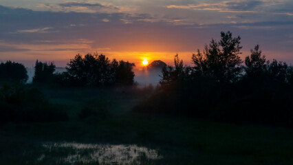 sunrise over a field in fog