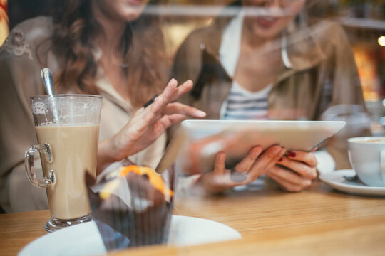 Women With a Tablet Sitting ina Coffee Shop