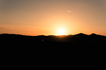 A portrait of an incredible view of a sunset with mountains