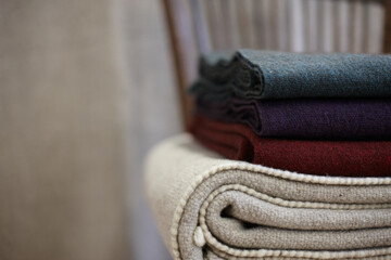 Stack of crafted plaids and blanket on a chair