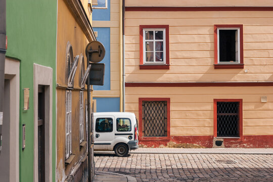 A Small Delivery Vehicle Parked Among Colorful Buildings in Cheb