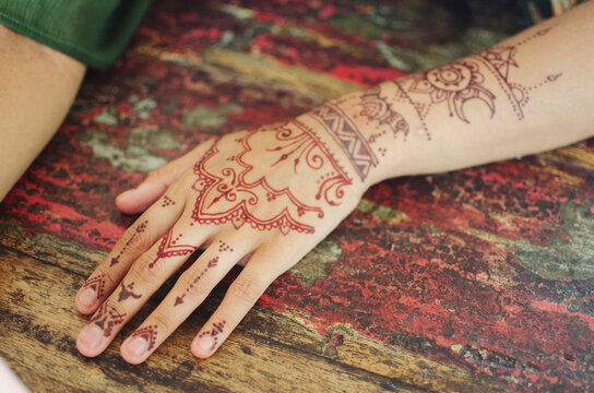 Henna tattoo being painted on hands