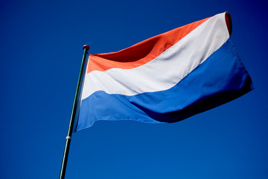 A waving dutch flag in a clear blue sky
