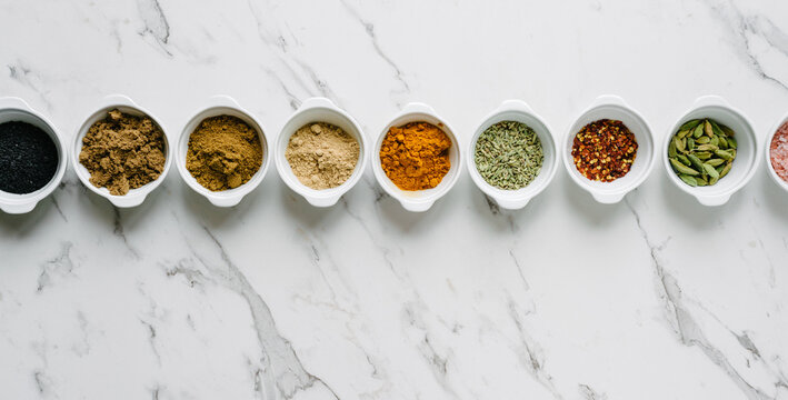 a row of spices against a marble background