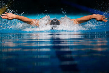 Male Swimmer Racing performing Butterfly Stroke