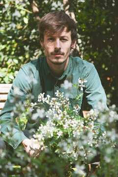 Young modern gardener man with fresh arugula on orchard.