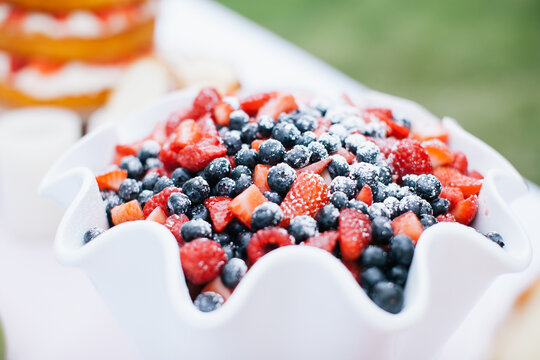 A bowl of sweetened blueberries and strawberries