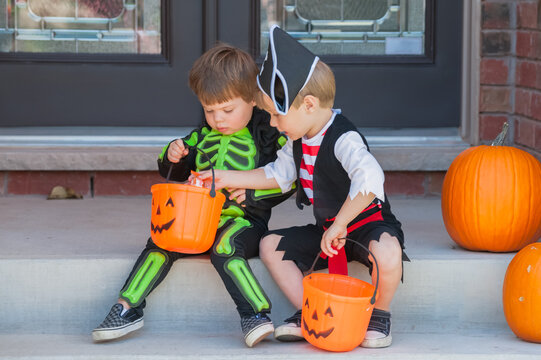 Trick-or-treating brothers comparing loot