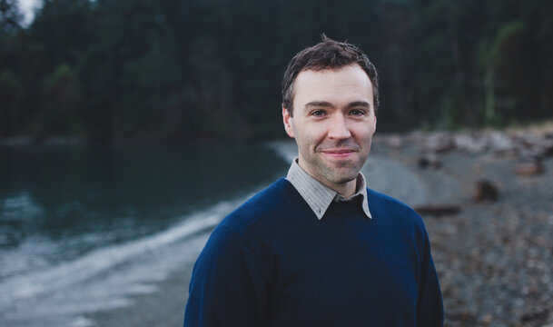 Handome man smiling near ocean in west coast winter