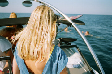 Back view of the woman having fun with fiends on boat
