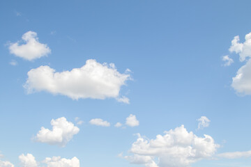 Obraz na płótnie Canvas White fluffy clouds against a bright blue sky.