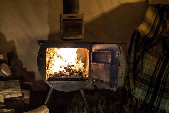 A wood stove burning inside a wall-tent in Montana.