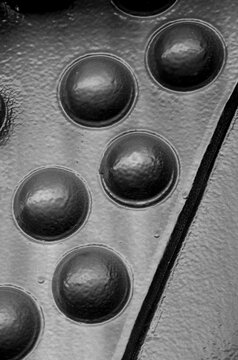 closeup macrophotograph of steel rivets on steam train engine black-and-white