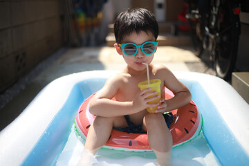 プールで飲み物を飲む男の子