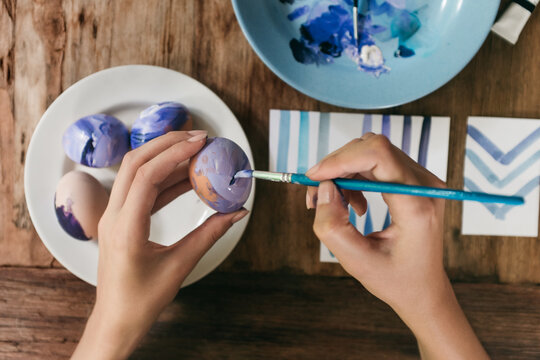 Woman Painting Purple Easter Eggs