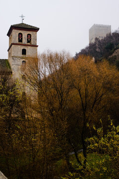 View of Alhambra's tower and San Pablo's church from El Paseo de los Tristes in Granada