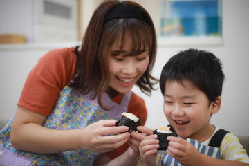 握ったおにぎりを食べる親子