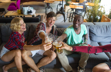 Group of attractive young people toasting with beer glasses