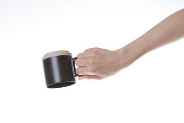 a hand holding a black coffee cup upside down.