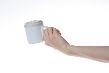 a hand holding a white coffee cup upside down.