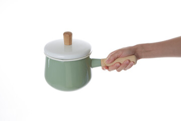 a hand holding a green pot with a lid on it.