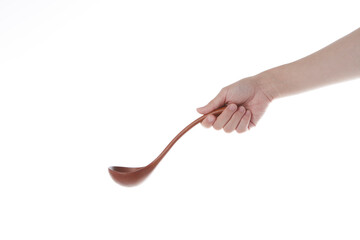 a hand holding a wooden ladle.