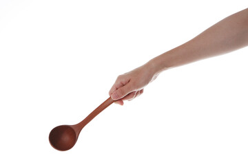 a hand holding a wooden ladle.
