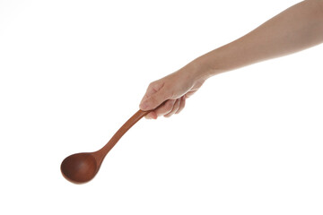 a hand holding a wooden ladle.