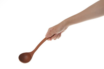 a hand holding a wooden ladle.
