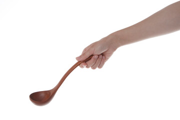 a hand holding a wooden ladle.