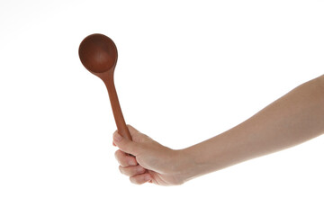 a hand holding a wooden ladle vertically.