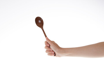 hand holding  wooden spoon. use the spoon.