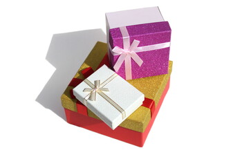 Three gift boxes of different colors stand on a white background