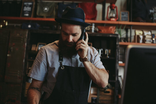 Beded man on phone making barber appointments