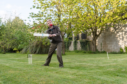 Man hits cricket ball with his bat