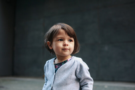 Cute little girl standing city alley downtown - staring into the distace
