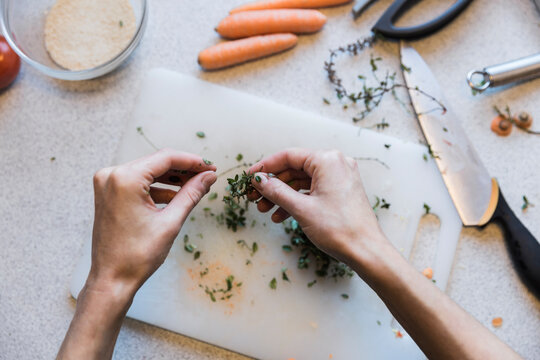 Hands stripping the leaves from thyme