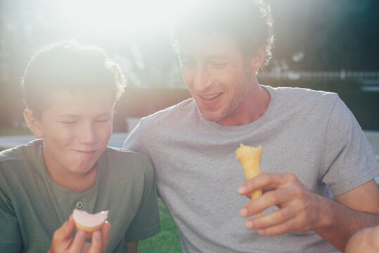 father and son bonding eating ice ream in summer