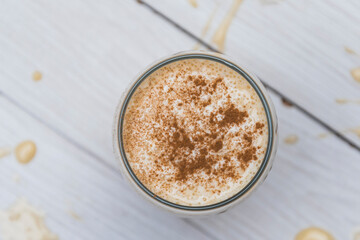 milkshake with banana, oats and cinnamon in a glass, top view, horizontal