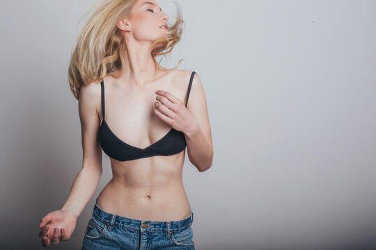 Sexy blonde woman in jeans and black bra.