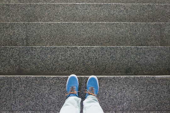 Blue sneakers on staircase, footsie, personal perspective