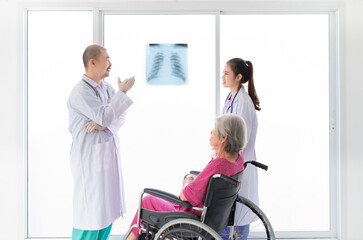 Fototapeta premium two Asian doctor looking patient film, they talk about symptoms and treatment plan of patient, they explain about disease with old patient, broken bone treatment, tuberculosis screening