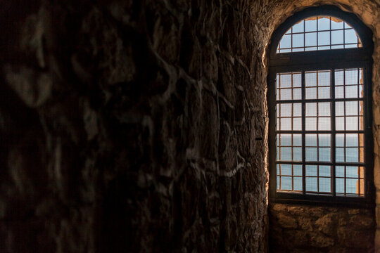 Looking along stone wall to window and ocean beyond in medieval building