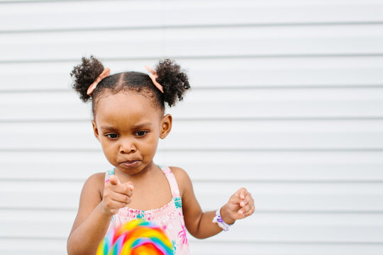 A little girl counting the lollipop colors