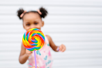 A little girl and her colorful lollipop