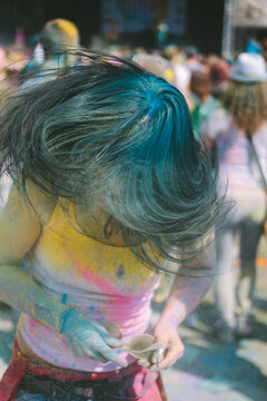 young black haired woman shaking color powder out of her hair